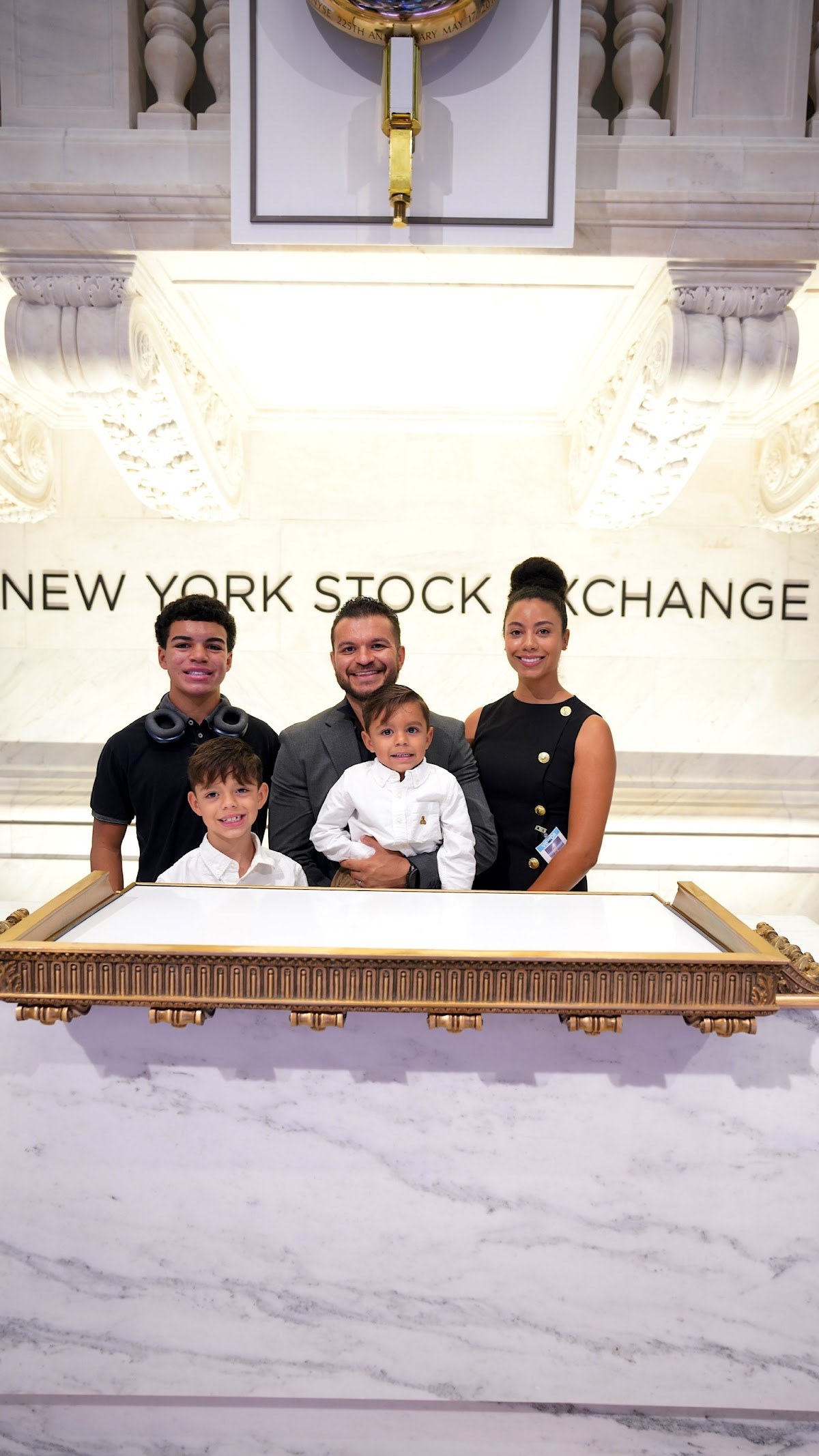 Andrew and his family at the New York Stock Exchange podium